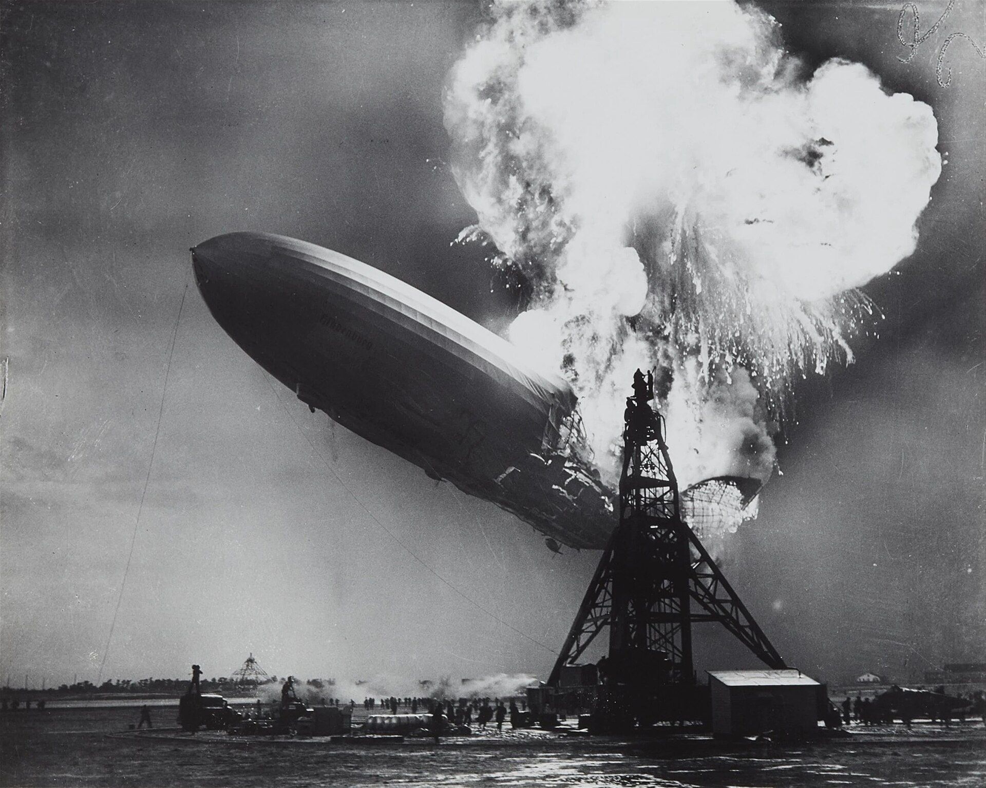 The airship Hindenburg engulfed in flame as it settles towards the mooring mast at Lakehurst