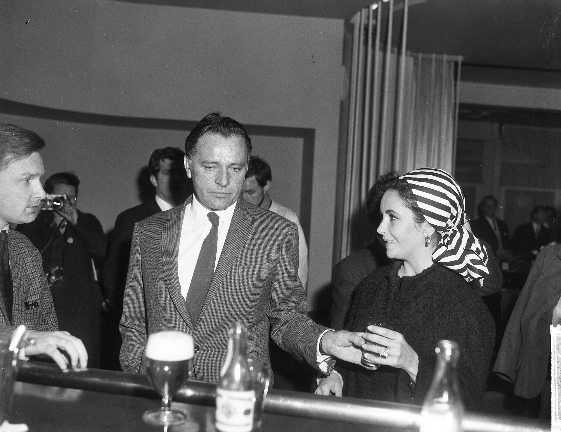 Elizabeth Taylor and Richard Burton sitting together at a hotel bar in the Netherlands in 1965