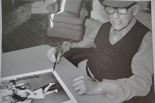Alfred Eisenstaedt signing a print of his V-J Day photograph at his cabin on Martha's Vineyard in August 1995