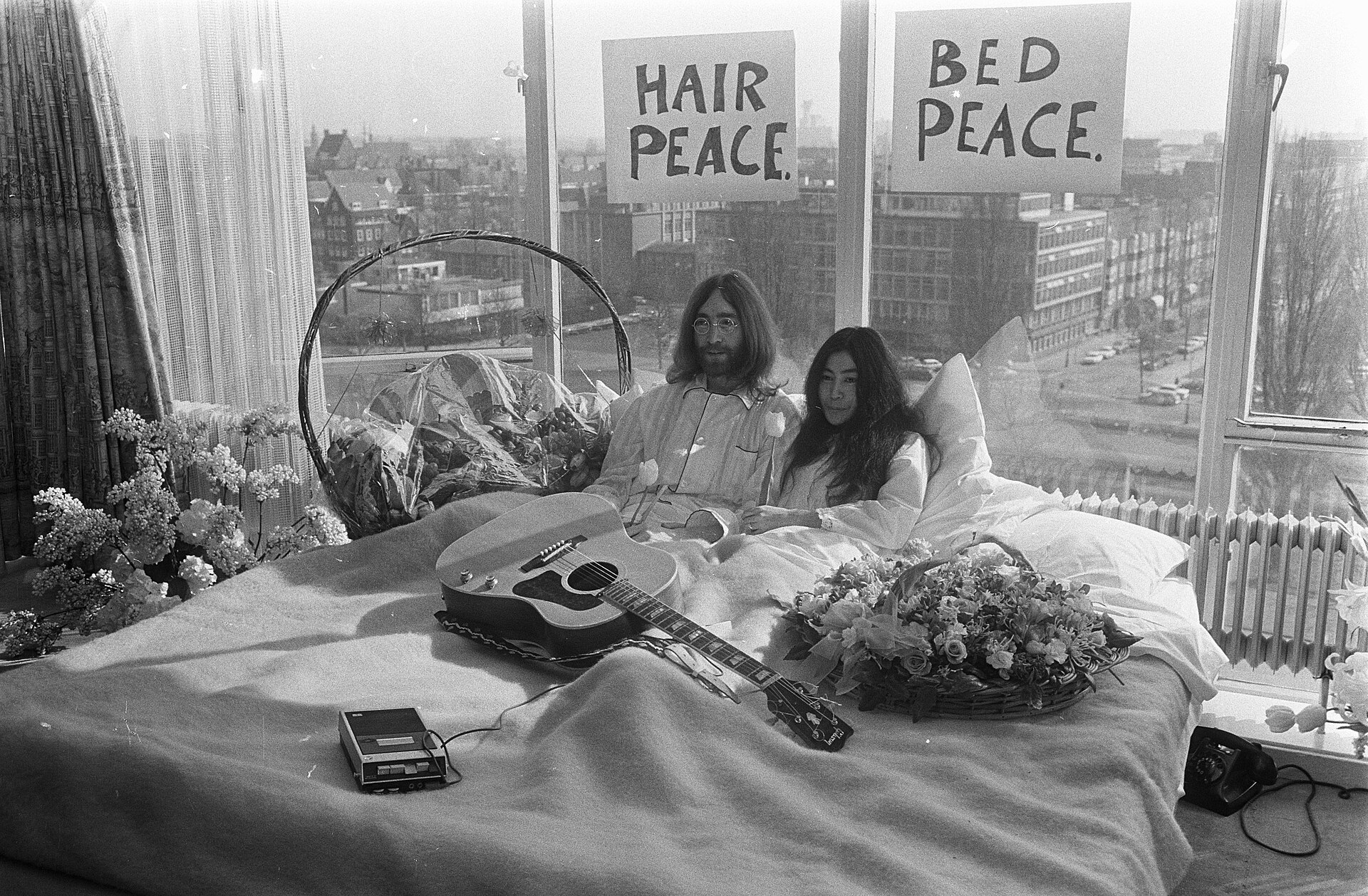 John Lennon and Yoko Ono in bed at the Amsterdam Hilton during their 1969 Bed-In for Peace, surrounded by press