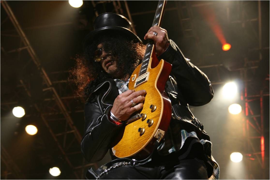 Slash performing on stage with a Les Paul guitar in 2010