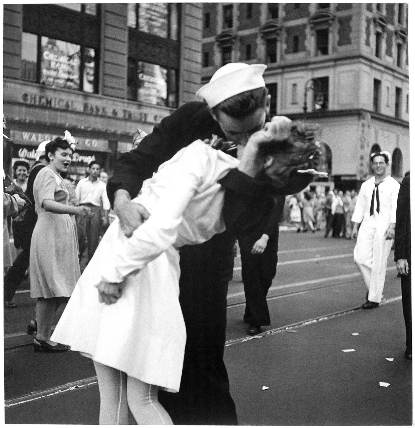 A sailor kissing a woman in a white dress in Times Square on 14 August 1945, photographed from street level by a US Navy photographer